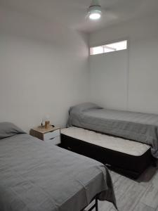 1 dormitorio con 2 camas y ventana en Amplio depto en PB con entrada independiente y doble cochera en Las Heras