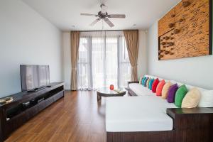 - un salon avec un canapé blanc et des oreillers colorés dans l'établissement VILLA PULAU | 2 Bedrooms Villa with Private Pool in Luxury Residence | 2 min to Naiharn Beach, à Nai Harn Beach
