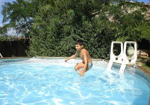 a young boy in a swimming pool next to a chair at Podere Valmarina in Follonica