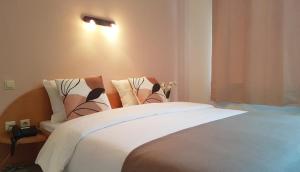a bedroom with a large bed with white sheets at Hôtel La Charbonnade in Dudelange
