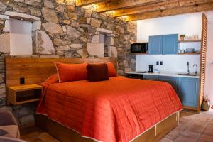 a bedroom with a bed and a stone wall at Villa Mosaico - Luxury Lofts in Real de Catorce
