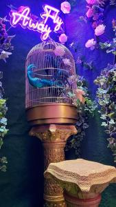 a bird in a bird cage with a neon sign at KERAMOS Athens in Athens