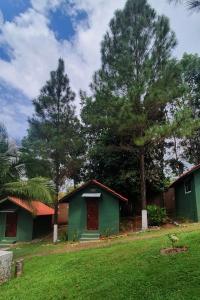 a green house with trees in a yard at LOS PINOS DE TORIO in Torio