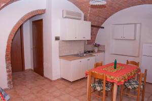 a kitchen with a table and a sink at Podere Valmarina in Follonica +9 photos