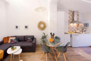 ein Wohnzimmer mit einem Sofa, einem Tisch und Stühlen in der Unterkunft Apartamento de diseño en Casco antiguo Altea in Altea