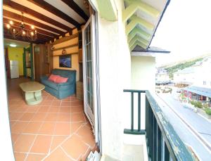 a balcony with a blue couch and a table at Loft Plaza Andalucía ERB Alojamientos in Sierra Nevada