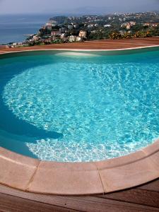 a large pool of water with a city in the background at Agriturismo Natta Di Monte Tabor in Celle Ligure