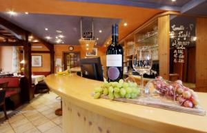 a bar with a bottle of wine and a bunch of grapes at REINHARDTs HOTEL in Buchen