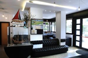 a black leather couch sitting in a room with a bar at Hotel Marbella in Cervia