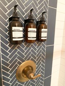 three bottles of soap on a wall in a bathroom at The Pink Room at Emily's On The Island in Galveston