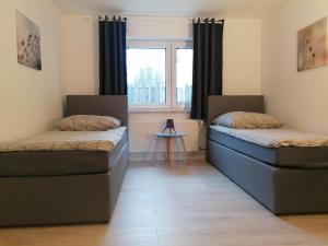 two beds in a room with a window at Nordunterkunft in Neumünster