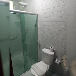 uma casa de banho com um WC e uma cabina de duche em vidro. em Pousada Vitória em Canindé de São Francisco