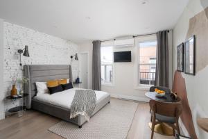 1 dormitorio con 1 cama y pared de ladrillo blanco en François-Denis Apartments en Montreal