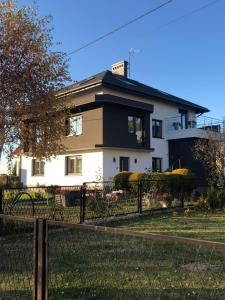 una gran casa blanca con una valla delante en Noclegi u Alicji en Wola Kalinowska