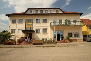 a large white building with benches in front of it at Pension Strohmer in Rust