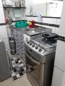 eine Küche mit einem Edelstahlherd und einer Spüle in der Unterkunft Apartamento Temporada Dalva Copacabana in Rio de Janeiro