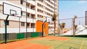 un campo da tennis con canestro da basket di fronte a un edificio di Resort Solar das Águas - Olímpia SP a Olímpia