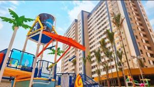 un parco giochi di fronte a un edificio con palme di Resort Solar das Águas - Olímpia SP a Olímpia