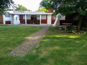 Piedra PintadaEl Chaparral Villa Dolores Traslasierra 2的一个带野餐桌的绿色庭院的房子