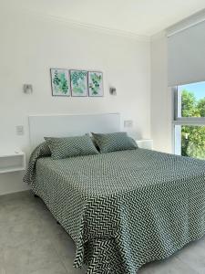 a bedroom with a bed with a black and white comforter at Milan Aparts in Colón