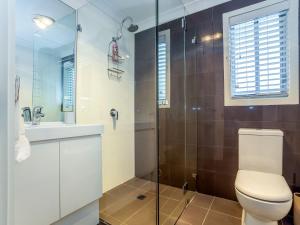 a bathroom with a toilet and a glass shower at Kiama Sunrise Kiama in Kiama +20 photos