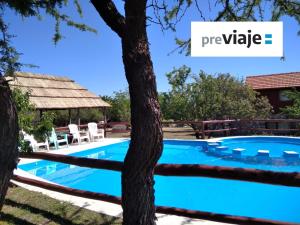 una piscina con un árbol y un cartel que diga privado en Cabañas Yanasuy en Merlo