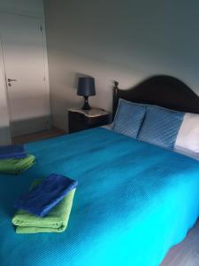 a bedroom with a blue bed with towels on it at Marisol Sunset in Charneca +48 photos