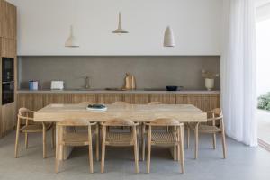 a kitchen with a wooden table and chairs at Villa Mimaze Minimalist Living in Elounda