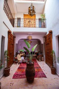 ein Wohnzimmer mit einer Topfpflanze auf dem Boden in der Unterkunft Riad Taziri in Marrakesch
