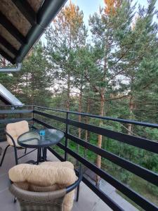 un balcone con tavolo, sedie e alberi di Luma Home a Divčibare
