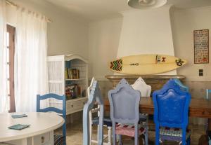 a surfboard hanging on a wall above a table with chairs at Santa Beach House in Santa Cruz