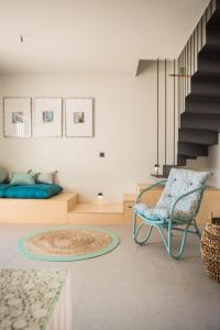 a living room with a chair and a table at Harmony Suites in Khelmáta +50 photos