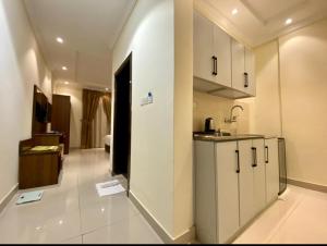 a kitchen with white cabinets and a sink in a room at Sky Blue Hotel in Al Baha