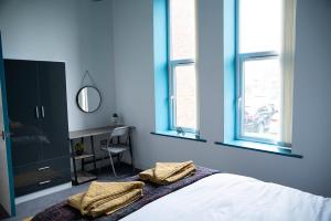 sypialnia z niebieskimi ścianami i łóżkiem z 2 ręcznikami w obiekcie Cosy Stays w mieście Redcar