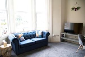 a blue couch in a living room with a tv at Cosy Stays in Redcar