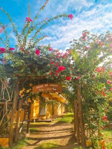 a garden with pink flowers and a sign at Pousada dos Cardeais in Barra Grande
