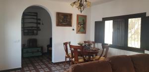 Una sala de estar con un sofá, una mesa y sillas. en El Molino de arriba, en Níjar