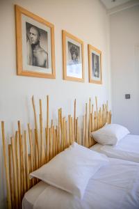 twee bedden in een kamer met houten palen en foto's aan de muur bij Pure apartments in Taroudant