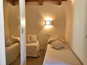 a room with two beds and a light on the wall at Inghirios Wellness Country Resort in Santa Maria la Palma