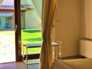 a room with a chair and a sliding glass door at Inghirios Wellness Country Resort in Santa Maria la Palma