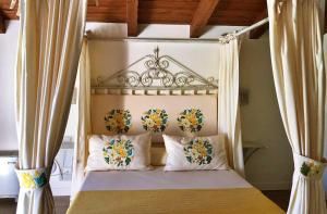 Un dormitorio con una cama con dosel y flores. en Inghirios Wellness Country Resort, en Santa Maria la Palma