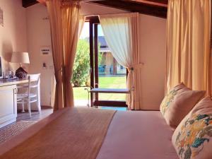 1 dormitorio con cama, escritorio y ventana en Inghirios Wellness Country Resort, en Santa Maria la Palma