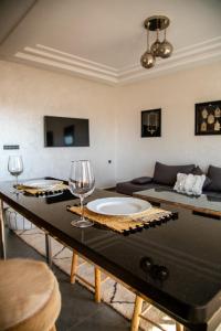 Pure apartments في تارودانت: غرفة معيشة مع طاولة مع كؤوس للنبيذ عليها