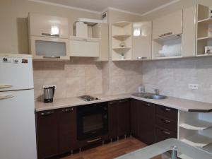 uma cozinha com um frigorífico branco e um lavatório em UpTown-Квартира em Vyshhorod