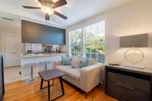 a living room with a couch and a kitchen at Tropical Nola Studio Vacation Rental in West Palm Beach