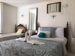 two swans sitting on a bed in a bedroom at Pousada Brasil Tropical in Bezerros