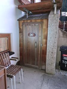 a wooden door with a sign on it next to two chairs at Appartement Gletscher-Koje in Tux