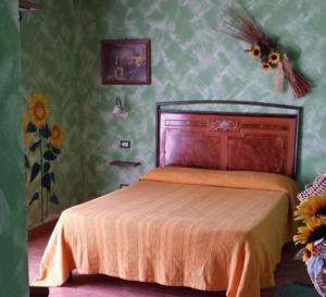 a bedroom with a bed with an orange bedspread at Agriturismo Il Maggio in Manciano