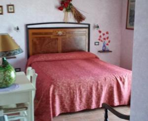 a bedroom with a red bed and a table with a lamp at Agriturismo Il Maggio in Manciano +3 photos