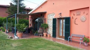 eine Veranda eines Hauses mit einer Bank im Hof in der Unterkunft Agriturismo Il Maggio in Manciano